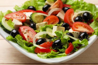 Beyaz ahşap masada leziz taze Yunan salatası, yakın plan.