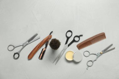 Many different barber's tools on light grey background, flat lay