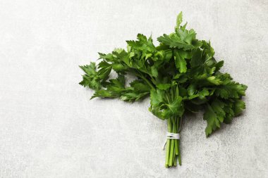 Bir demet taze maydanoz, gri desenli masa, üst manzara. Metin için boşluk