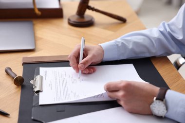 Ofisteki ahşap masada noter imzalı belge, yakın plan.