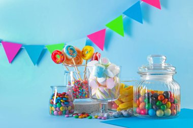 Candy bar. Many different sweets on light blue background. Space for text