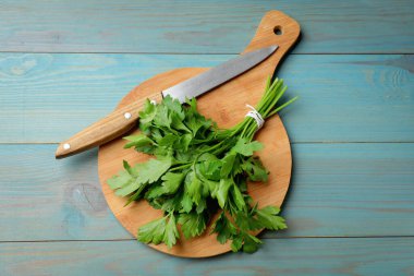 Taze maydanoz, bıçak ve tahta kesme tahtası mavi ahşap masa, üst manzara