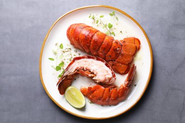 Gri masada servis edilen lezzetli haşlanmış ıstakoz kuyrukları.