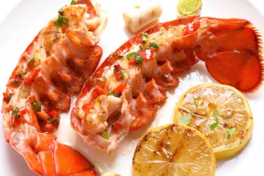 Limonlu ıstakoz kuyruğu, mikroyeşiller ve beyaz tabakta yeşil soğan, yakın plan.