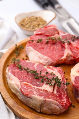 Açık gri masada çiğ et ve baharat parçaları, yakın plan.