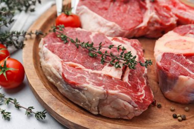 Açık gri masada çiğ et ve baharat parçaları, yakın plan.