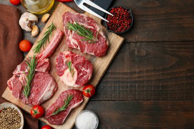 Çiğ et parçaları, biberiye ve ahşap masa üzerindeki ürünler. Metin için boşluk