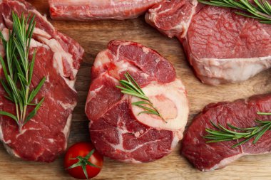 Çiğ sığır eti, biberiye ve domates parçaları ahşap masada, düz yatıyordu.