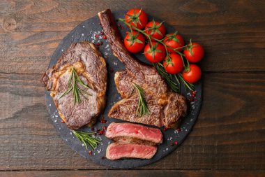 Lezzetli et parçaları, ahşap masada baharatlar ve domatesler.