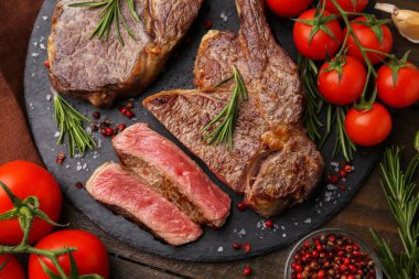 Lezzetli et parçaları, baharatlar ve domatesler masada, düz yerde.