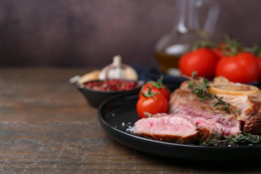 Lezzetli et parçaları, ahşap masada baharatlar ve domatesler, yakın plan. Metin için boşluk