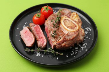 Lezzetli et parçaları, kekik, yeşil arka planda tuz ve domates, yakın plan.