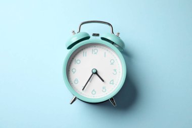 Açık mavi arkaplanda turkuaz alarm saati, üst görünüm