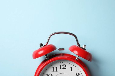 Açık mavi arka planda kırmızı alarm saati, üst manzara. Metin için boşluk