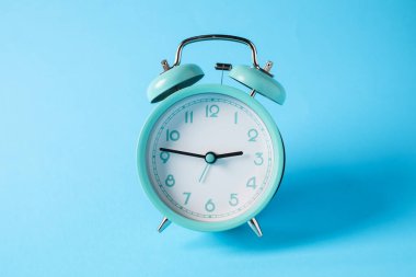 Açık mavi arkaplanda turkuaz alarm saati