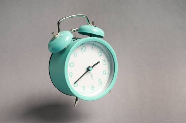 Açık gri arkaplanda turkuaz alarm saati