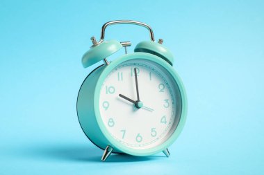 Açık mavi arkaplanda bir turkuaz alarm saati