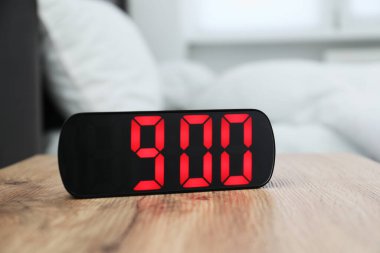 Dijital alarm saat 9: 00 'da kapalı bir masada.