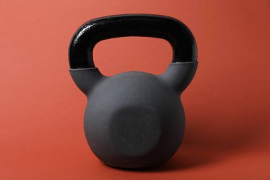 Turuncu arka planda bir tane kettlebell. Spor malzemeleri.