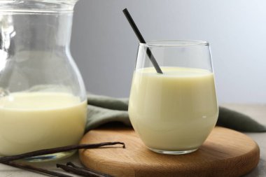 Gri masadaki lezzetli vanilyalı süt ve kapsüller