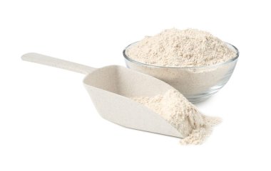 Kahverengi pirinç unu kasede ve kepçeyle beyaz üzerine izole edilmiş