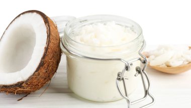 Kavanozda organik hindistan cevizi pişirme yağı, kaşık ve ahşap masada beyaz arka planda taze meyve