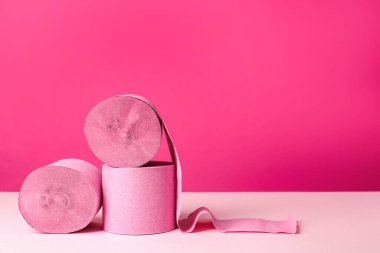 Pembe arka planda renkli tuvalet kağıdı ruloları. Metin için boşluk