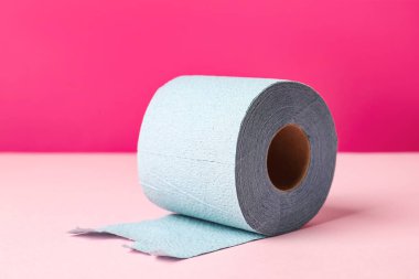 Pembe arka planda mavi tuvalet kağıdı rulosu