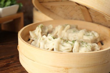 Tahta masadaki bambu buharlı tencerede kaynamış gyoza (hamur tatlısı), yakın plan.