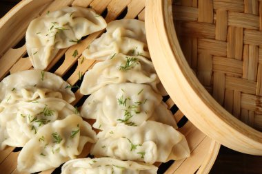 Tahta masadaki bambu buharlı tencerede kaynamış gyoza (hamur tatlısı).