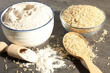 Kahverengi pirinç ve un gri masada, yakın plan.