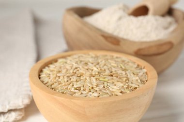 Kahverengi pirinç ve un beyaz ahşap masada, yakın plan.