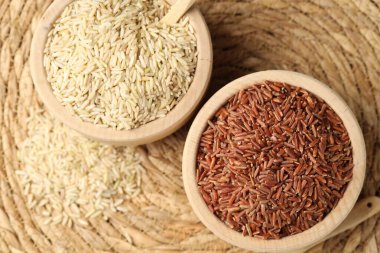 Hasır hasırın üzerinde farklı türde çiğ kahverengi pirinç, üst manzara.