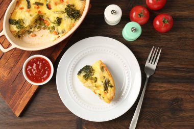 Ahşap masada sos ve baharatla servis edilen lezzetli sebze güveci.