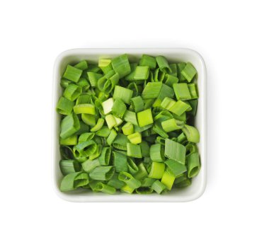 Taze doğranmış yeşil soğan kasede, beyaz manzarada izole edilmiş.