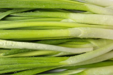 Arka planda su damlaları olan taze yeşil soğanlar, üst görünüm