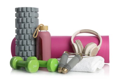 Beyaza izole edilmiş farklı spor aletleri ve kulaklıklar.