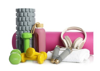 Beyaza izole edilmiş farklı spor aletleri ve kulaklıklar.