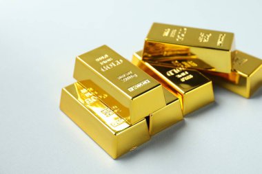 Açık arkaplanda parlak altın çubuklar, yakın plan