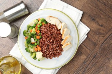 Tahta masada servis edilen tavuk ve sebzeli lezzetli kahverengi pirinç.