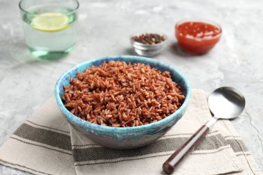 Gri desenli masada servis edilen lezzetli kahverengi pirinç, yakın plan.