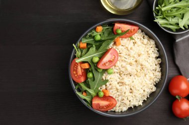 Siyah ahşap masa üzerinde sebzeli lezzetli kahverengi pirinç, düz yatıyordu. Metin için boşluk