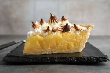 Gri desenli masada kahverengi kremalı bir parça lezzetli turta, yakın plan.