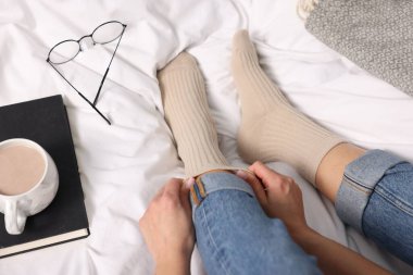 Yatakta bej çoraplı bir kadın, yakın plan.