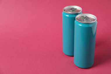 İki teneke kutu pembe arka planda. Metin için boşluk