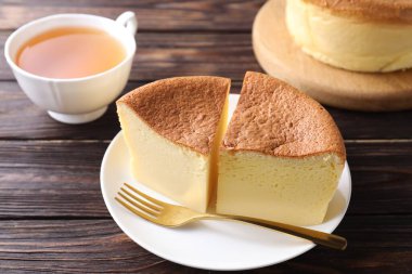 Lezzetli Japon Castella sünger kek, ahşap masa üzerinde çay ve çatal, yakın çekim