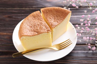 Lezzetli Japon Castella sünger keki, çingene çiçeği ve ahşap masa çatalı, yakın plan.