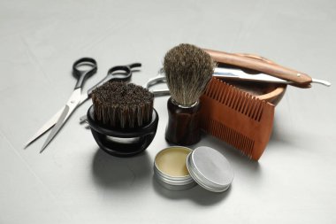 Açık gri masada birçok farklı berber aleti var, yakın plan.