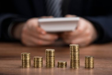 Ahşap masada çalışan adam, para yığınlarına odaklan.