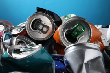 Mavi arka planda birçok buruşuk teneke kutu, yakın plan